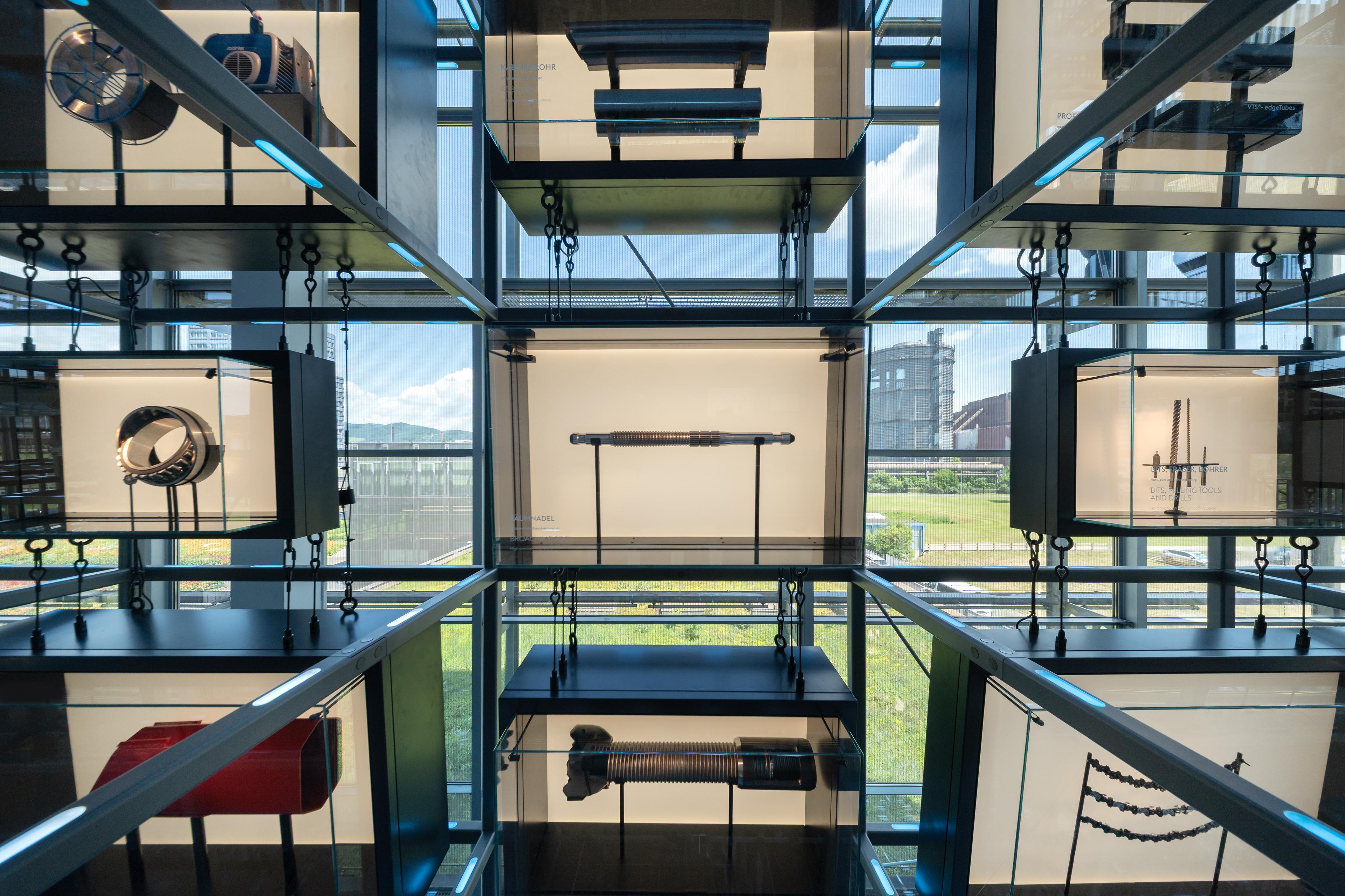 Steel components and high-tech products are displayed in illuminated showcases integrated into the Grid, highlighting the diversity of voestalpine applications and industries