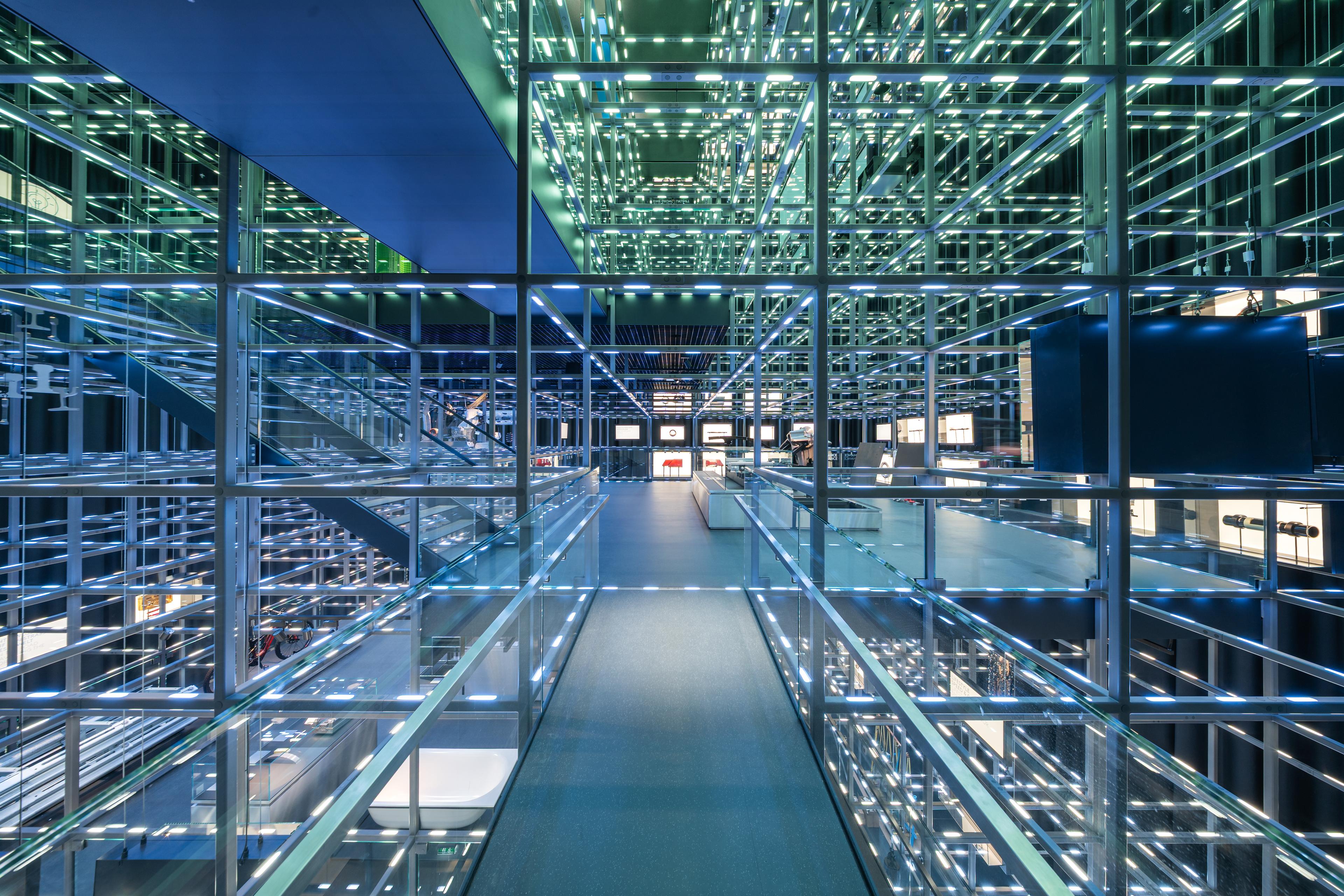 Elevated walkways lead visitors through the illuminated Grid, a 14-meter-high suspended steel structure that connects exhibits and creates a layered spatial experience